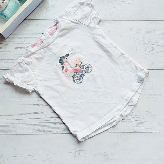 Polera de algodón blanco con diseño de niña con bicicleta de 6 meses  Tribu  Tiki taka